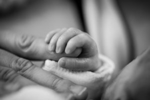תינוק מחזיק ביד ההורה